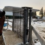 a standing horse in front of a feeders
