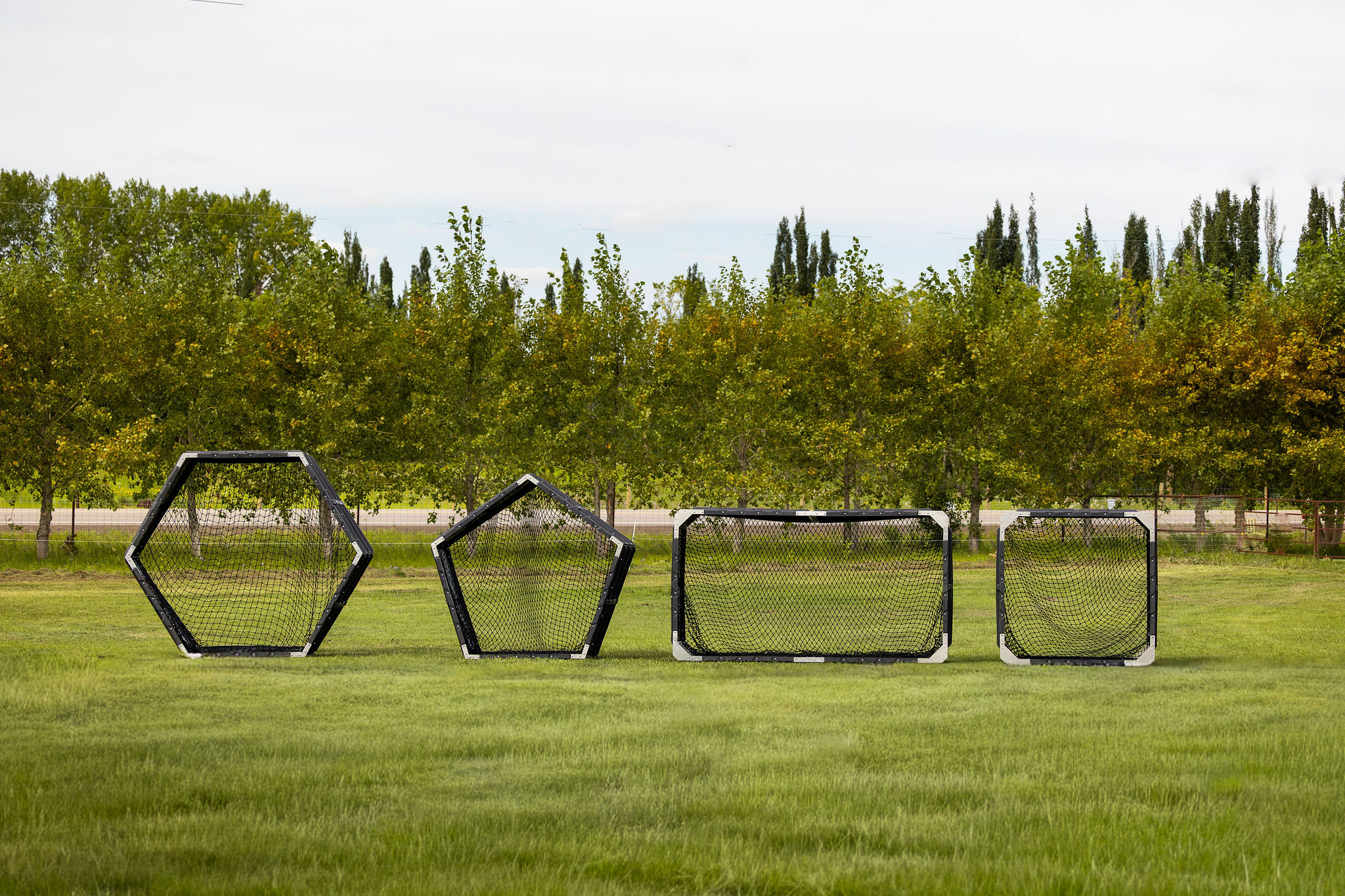 HayBoss Ring Feeder Line standing upright with black nets installed. Heavy-duty galvanized steel hay feeders for cattle, horses, goats, and sheep. Models: Big Round Ring Feeder, Small Round Ring Feeder, Big Square Ring Feeder, Small Square Ring Feeder.